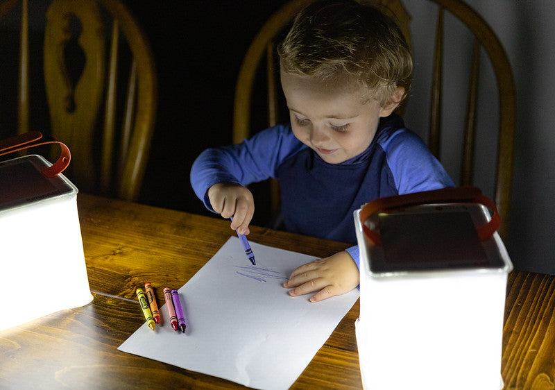 Boy coloring in the dark with lantern. Source: Nick Zupancich