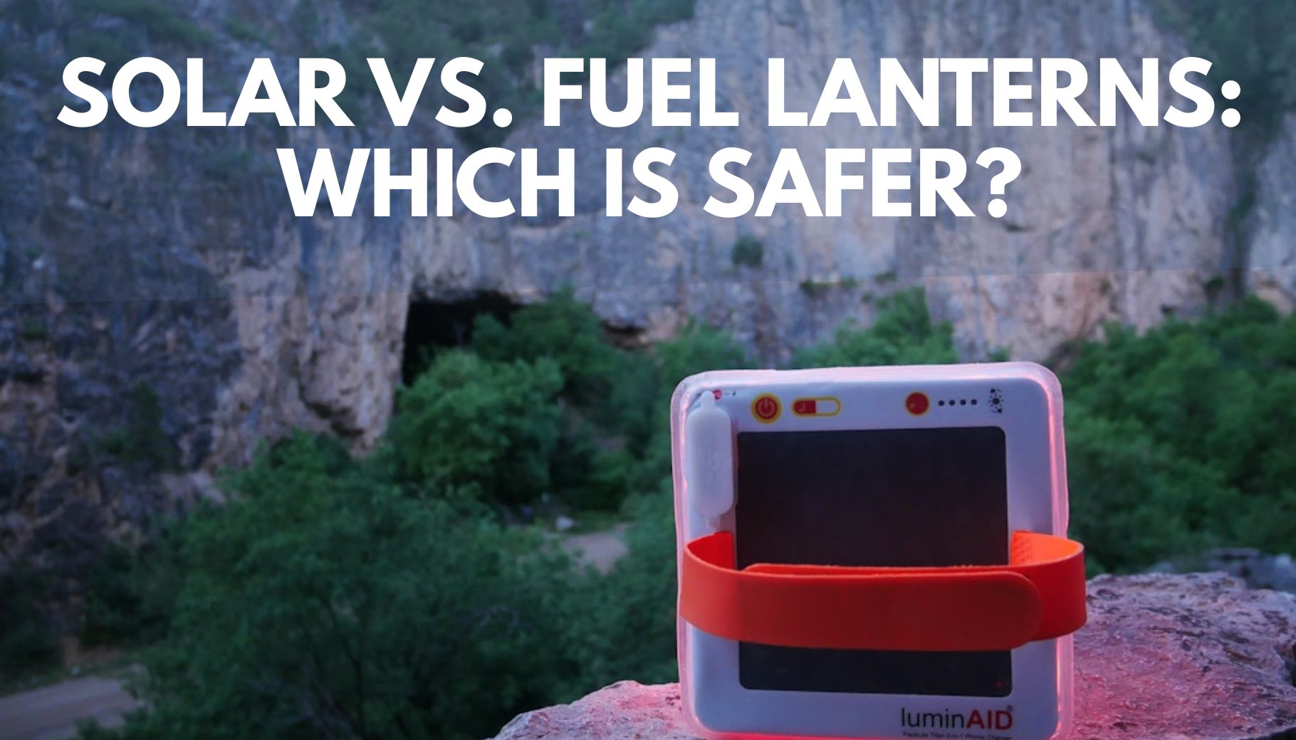 inflatable solar lantern sitting on its side on a rock with a cliff in the background