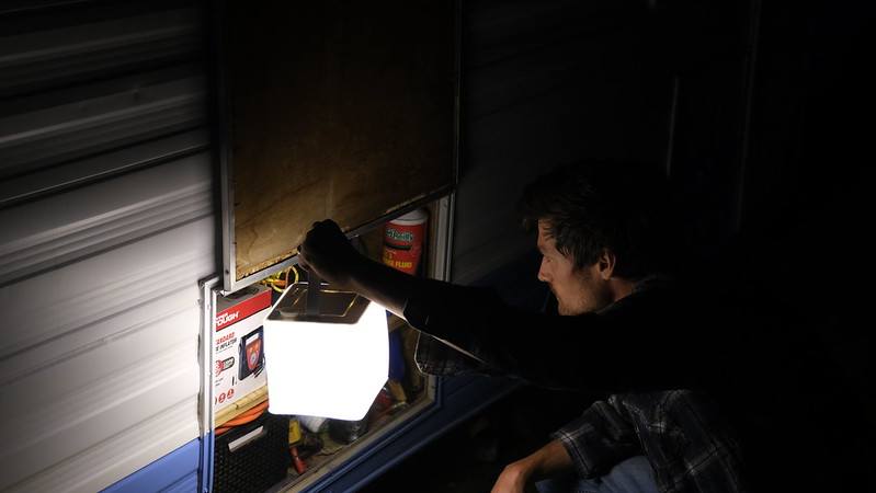 Person using LuminAID lantern in darkness. Source: Madison White @whitehomeonwheels