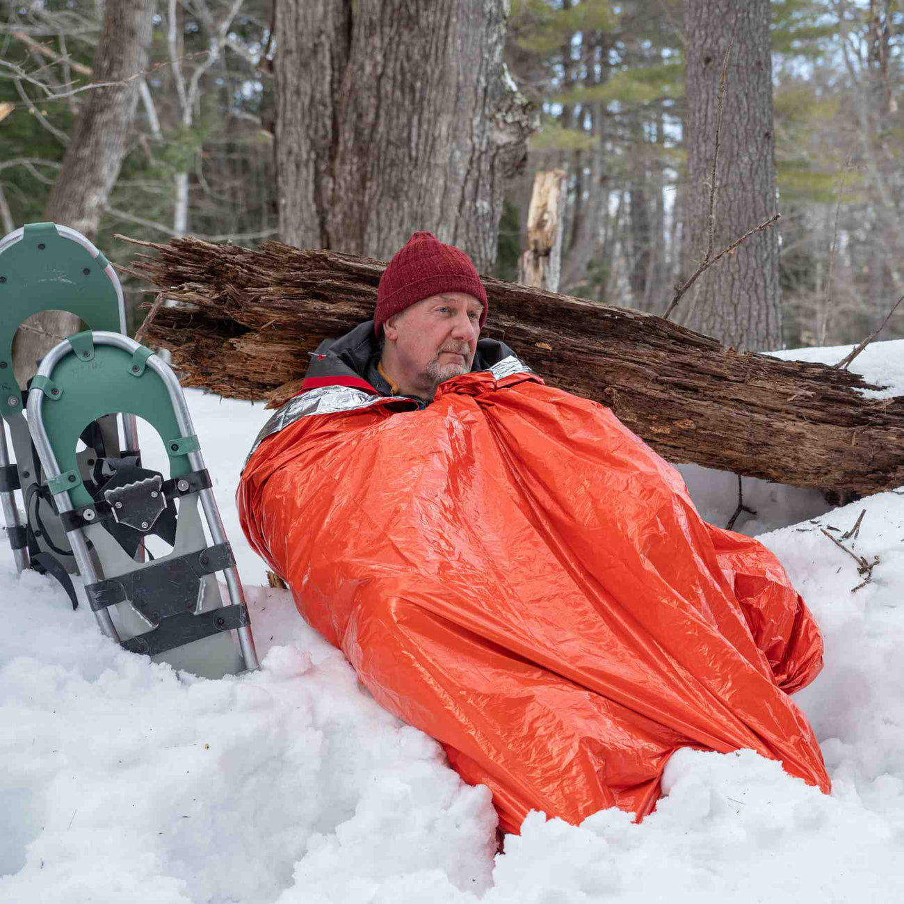 Emergency Bivvy XL in use in the snow as a man waits for rescue