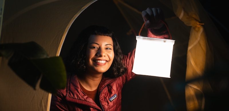 Woman in tent with Survivor lantern