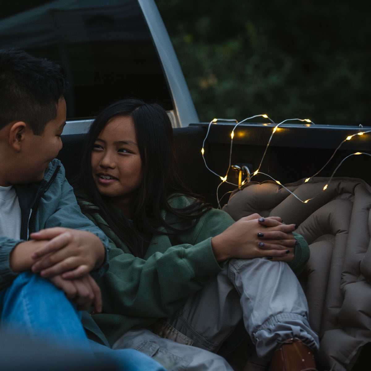 LuminAID Solar String Lights two people sitting next to string lights wrapped around railing