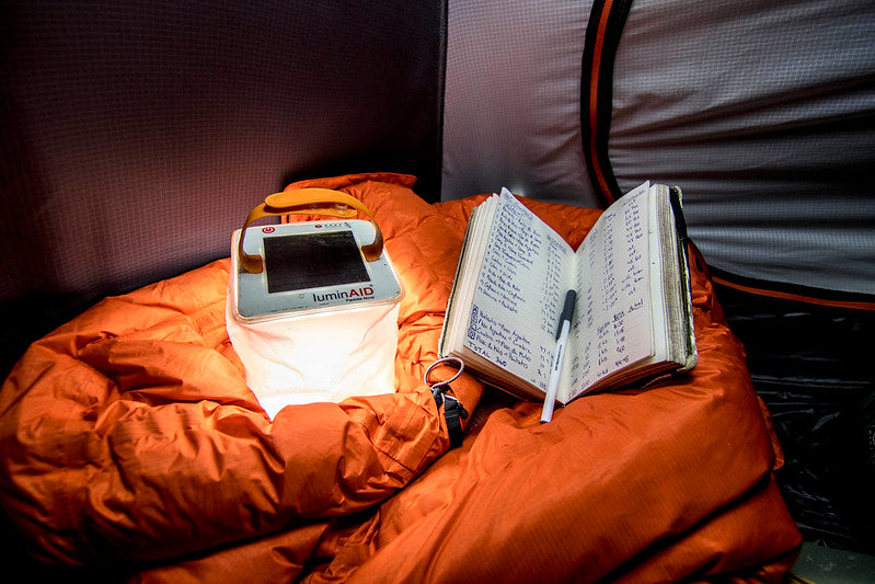 Lantern and notebook in a tent at night