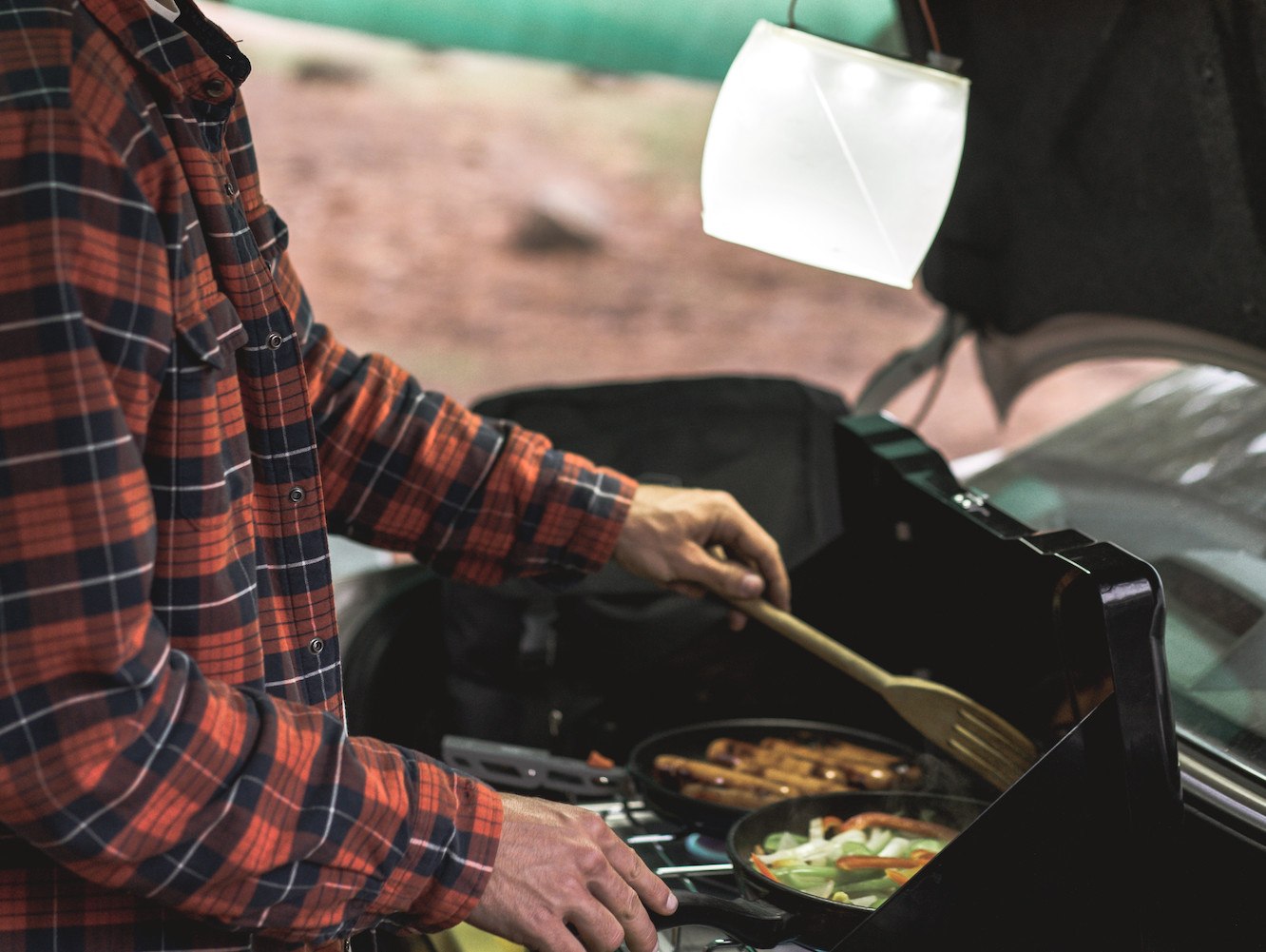 Man cooking at a campsite with a LuminAID