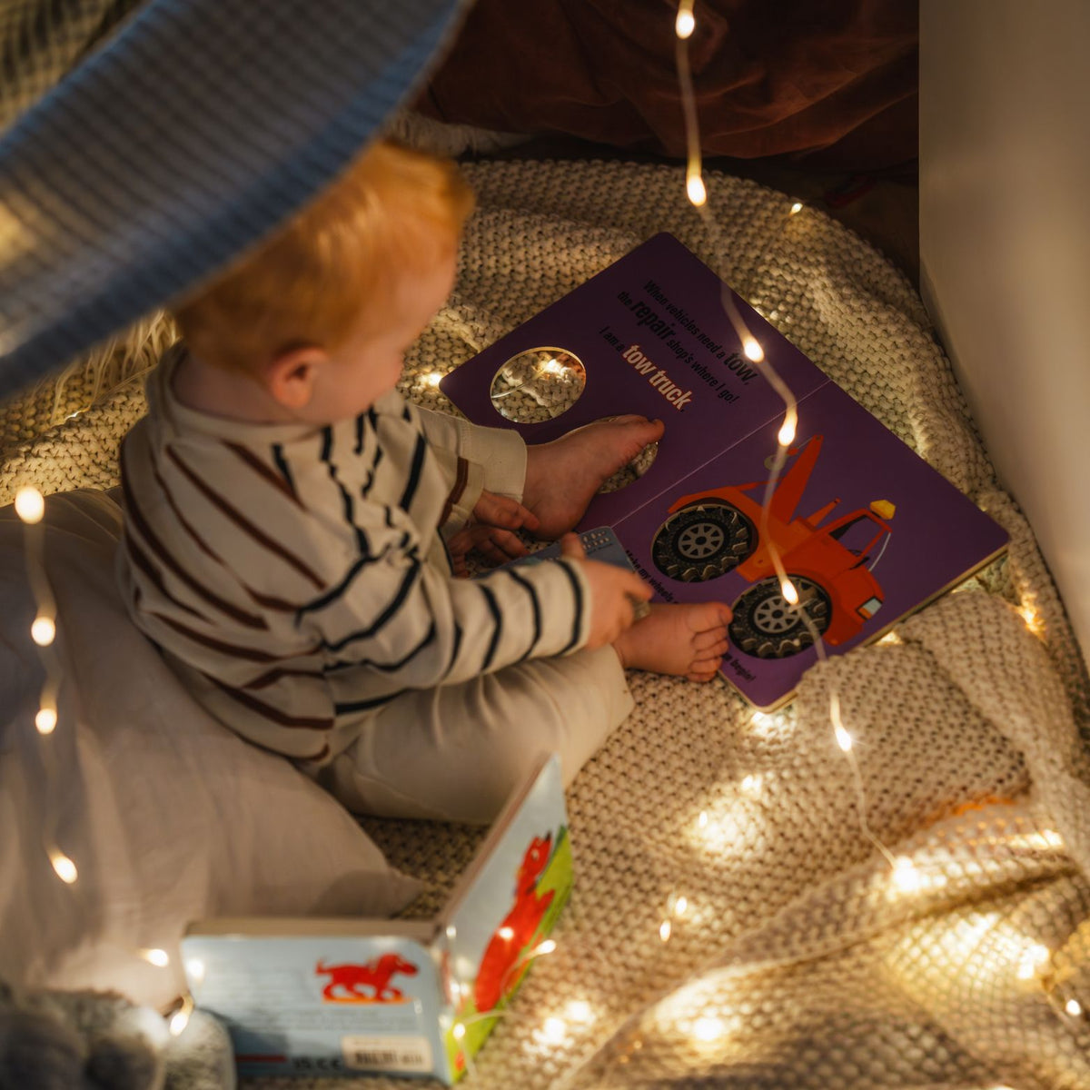LuminAID Solar String Lights child on blanket reading by lit string lights