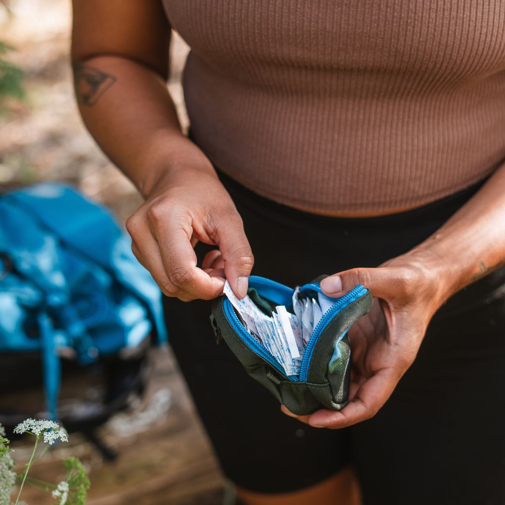 Woman opening the Mini Medical Kit to show bandages inside