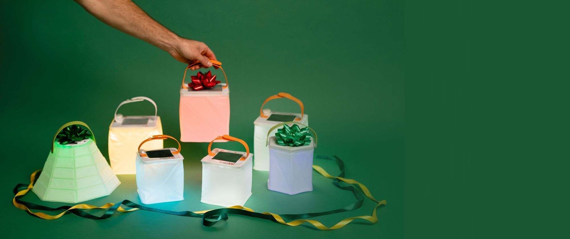LuminAID lanterns decorated with bows on a green background