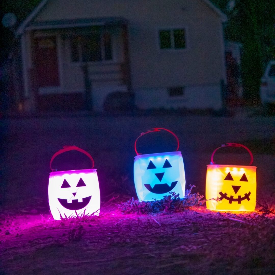 3 LuminAID jack-o-lanterns in front of a house