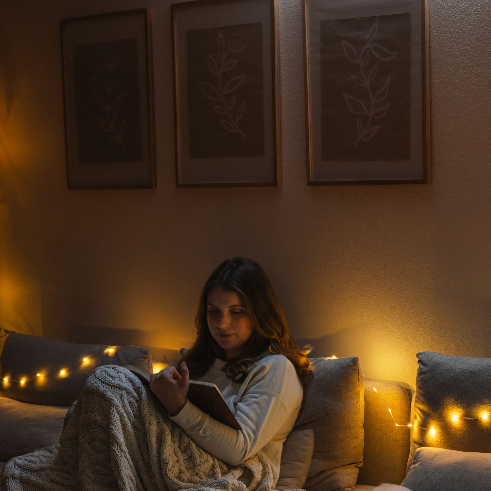 Woman reading indoors with solar string lights