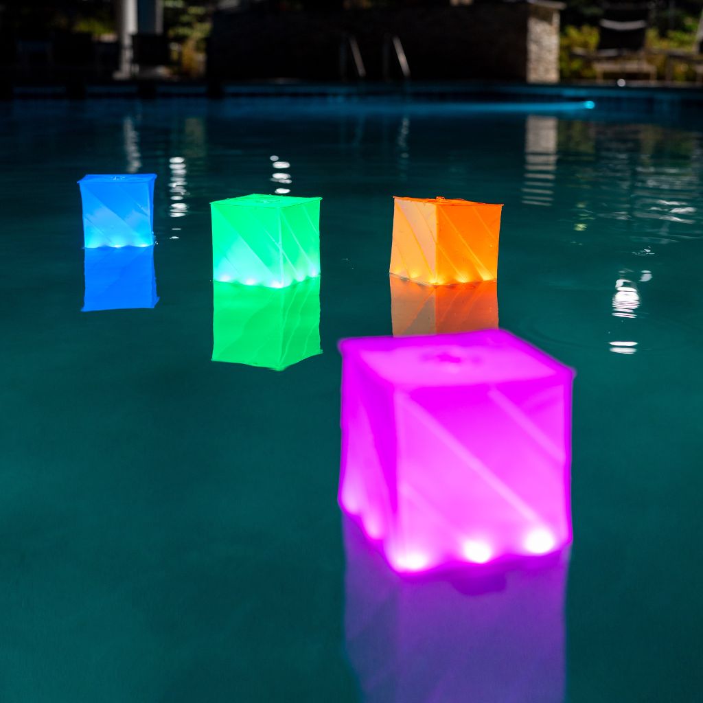 Mult-colored lanterns floating in a pool at night