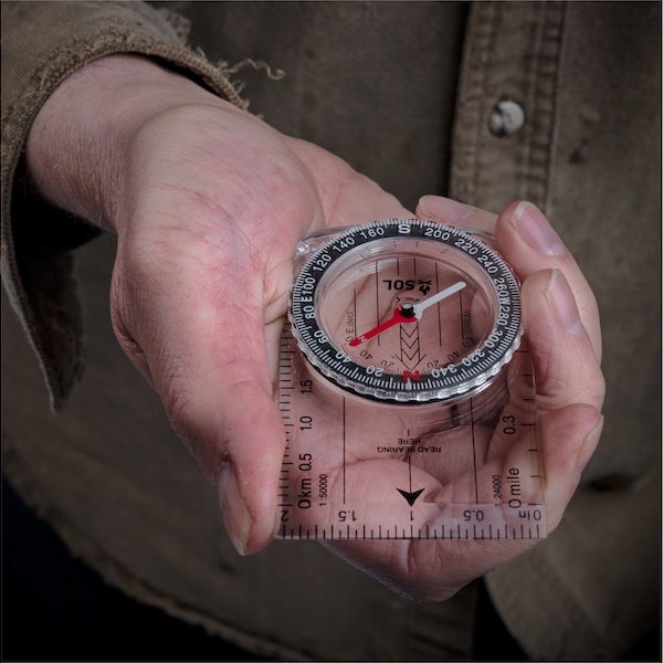 Close-up of the map compass being held in a hand