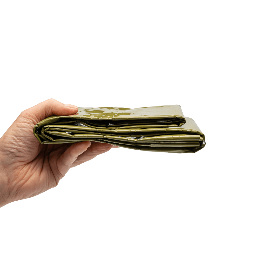 Survival blanket folded and held in a hand