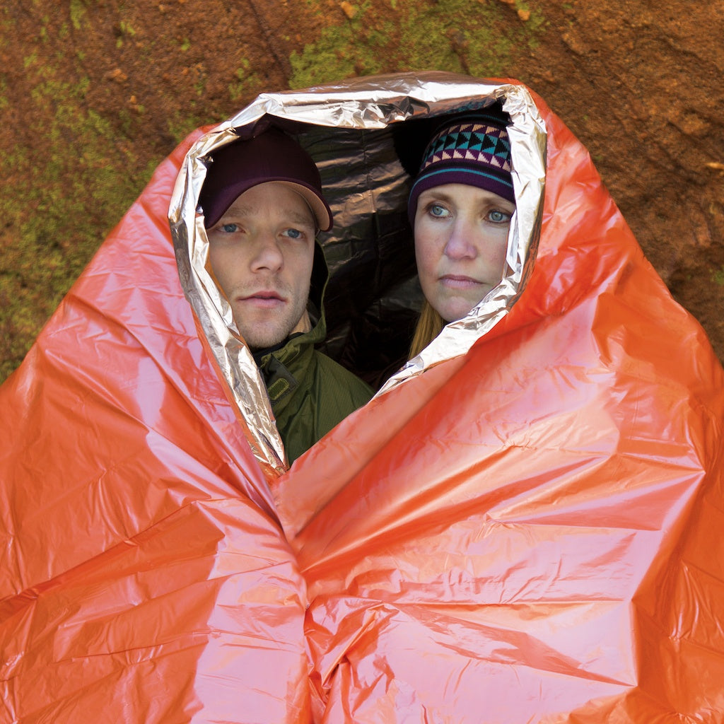 Two hikers sharing the survival blanket