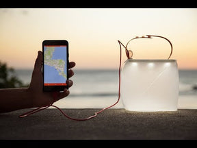 Packlite max 2-in-1 power lanterns charging a phone.