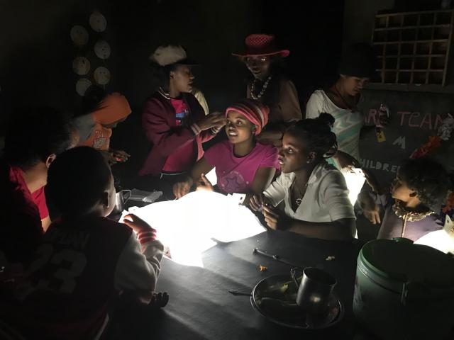 Girls using a LuminAID solar lantern at night