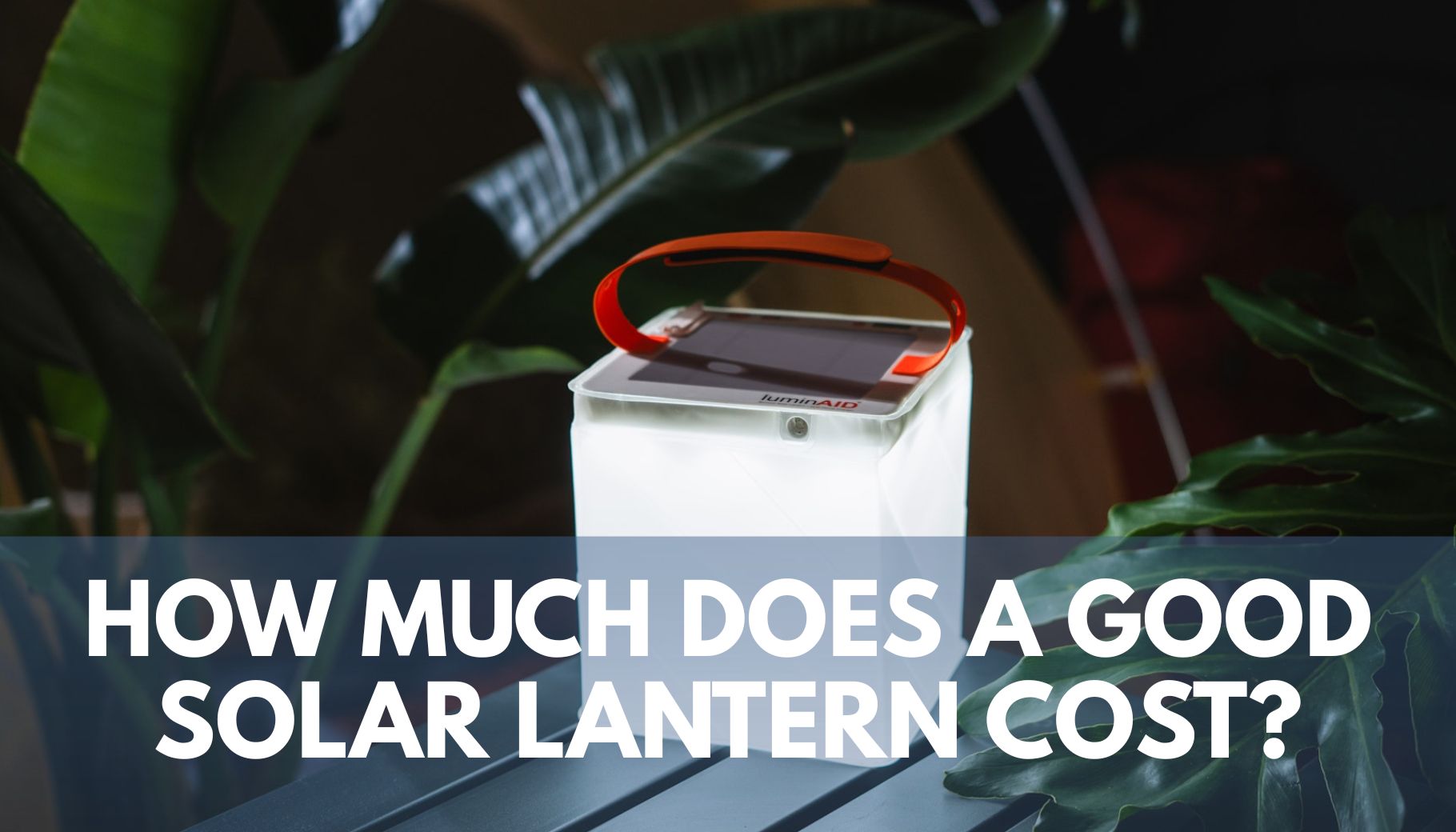 an illuminated solar lantern sitting on a table with plants in the background