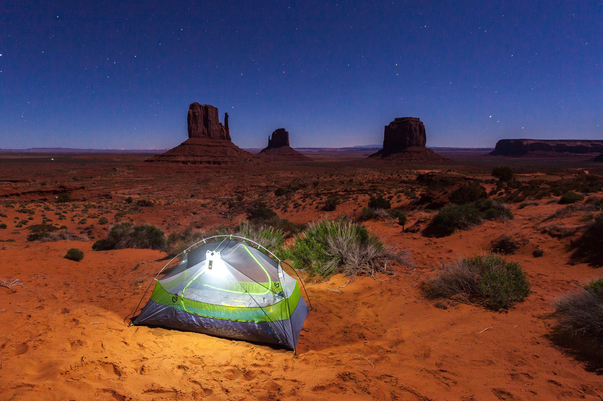 Tent in the desert with a starry night sky above