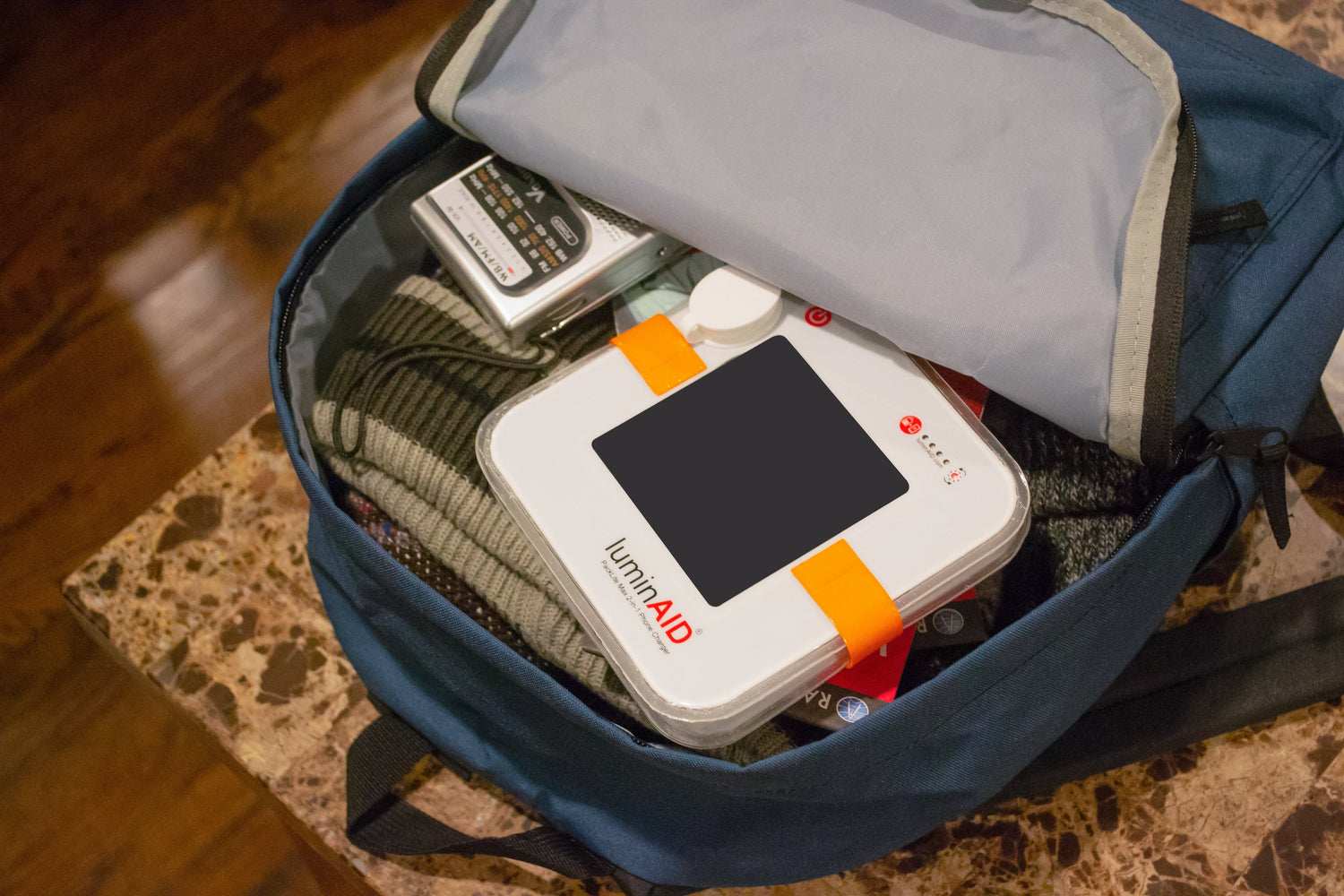 lantern sitting in open blue backpack packed with emergency supplies