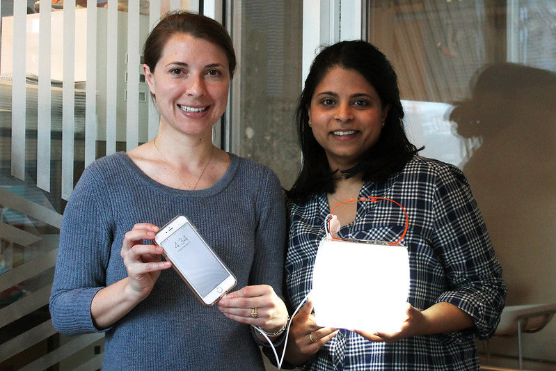 Co-Founders Anna and Andrea with a power lantern charging a phone.