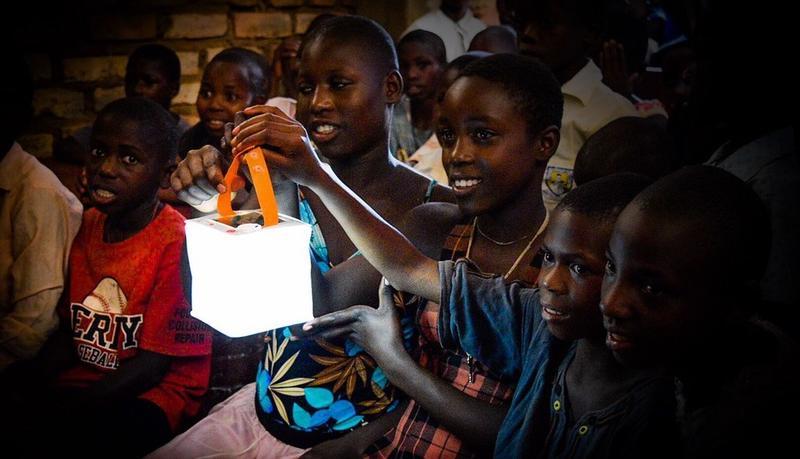 Kids hold up solar light bu the strap.