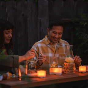 Couple eating dinner lit by Trio lanterns