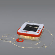 LuminAID Solar String Light glowing softly against a neutral gray background.