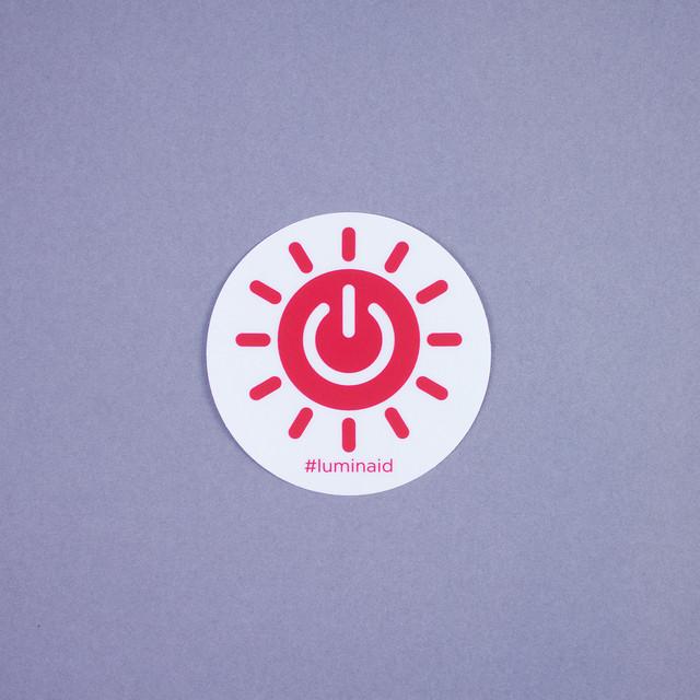 Luminaid Sticker, sun logo and #luminaid.