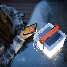 Titan lantern charges a phone in use and lights up the area.